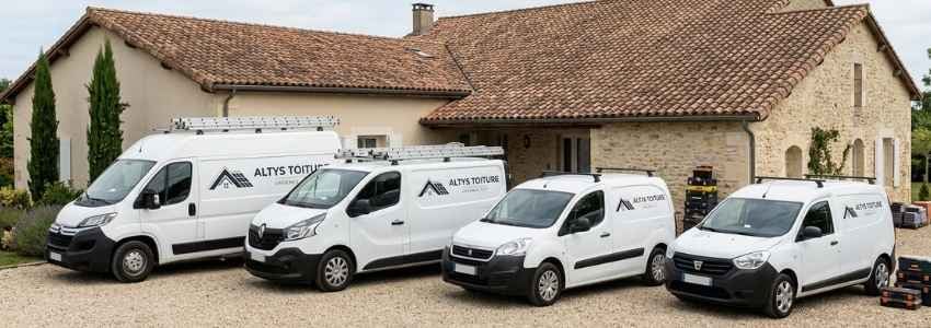 Les fourgons logotés Altys Toiture Libourne alignés devant une maison girondine en tuile canal